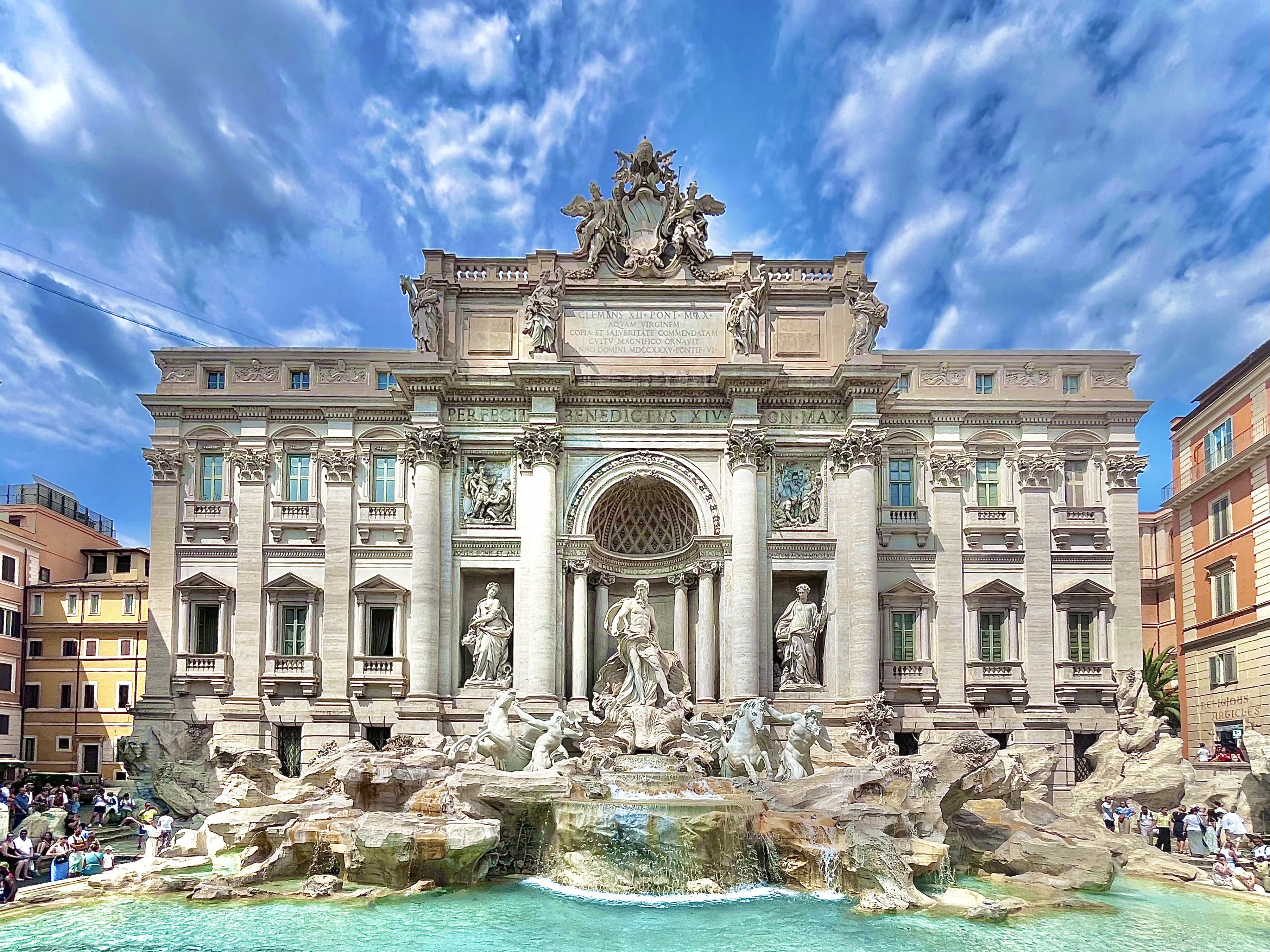 The Trevi Fountain in Rome under a bright blue sky